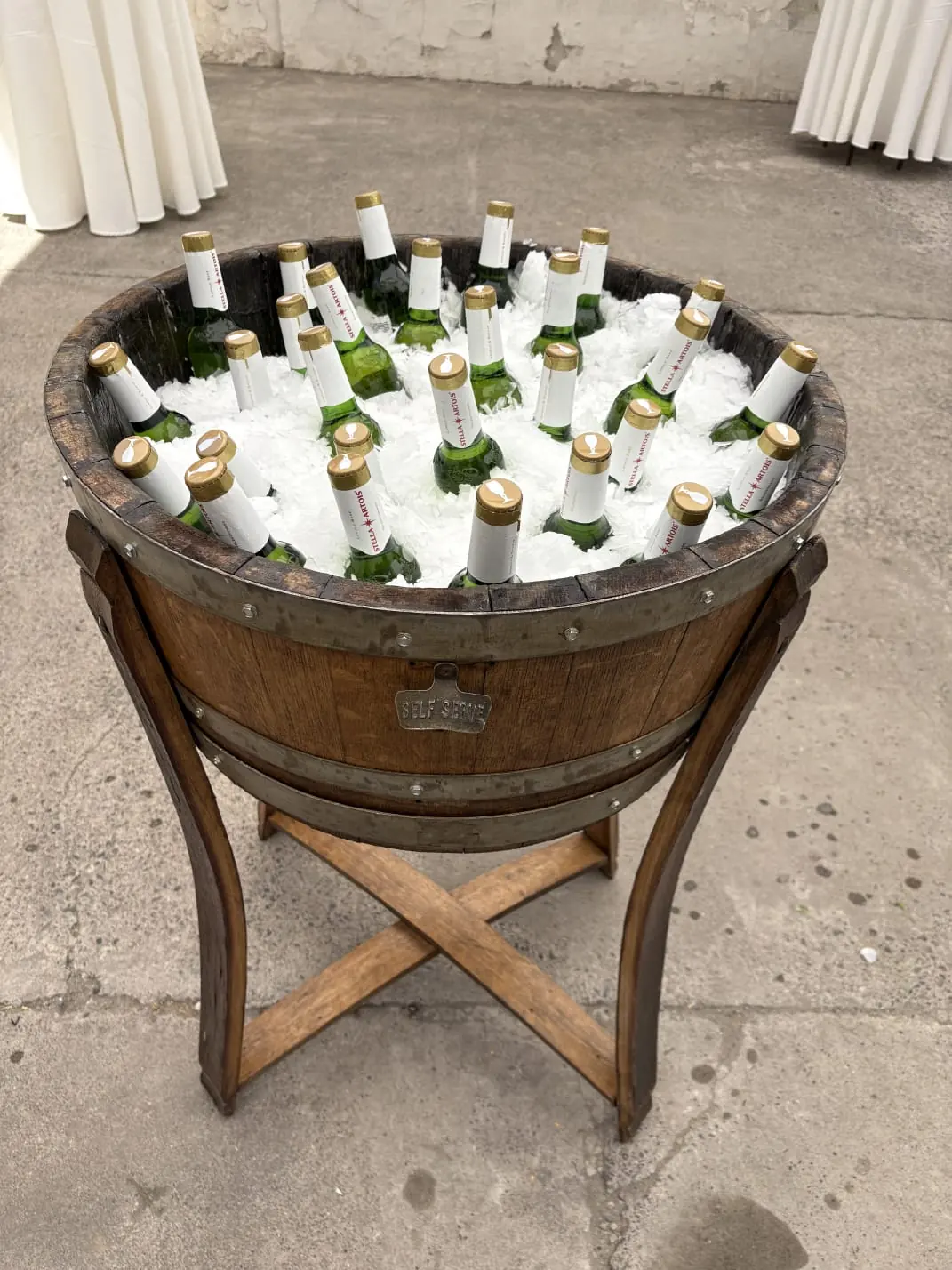 Hielera de barrica llena de botellas sobre hielo
